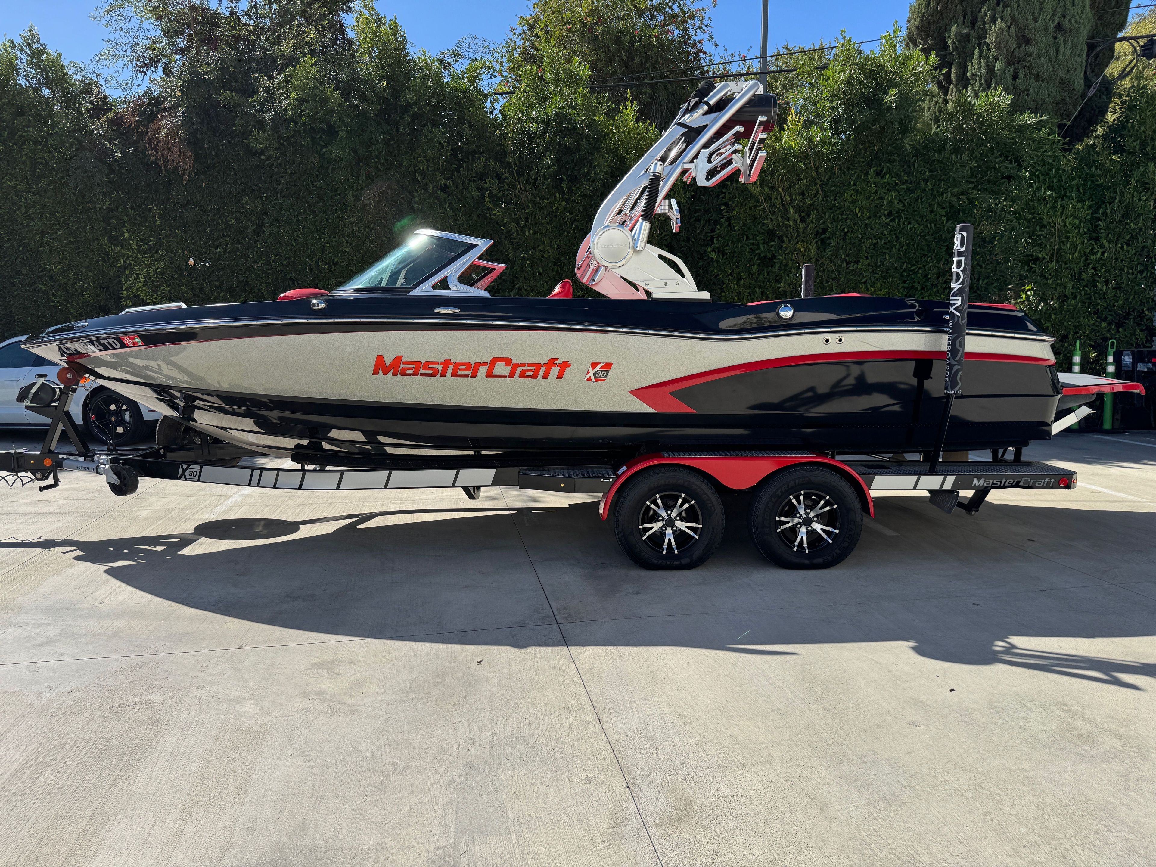 MasterCraft X30 2015 MasterCraft X30 boat on trailer, sleek design, parked outdoors.
