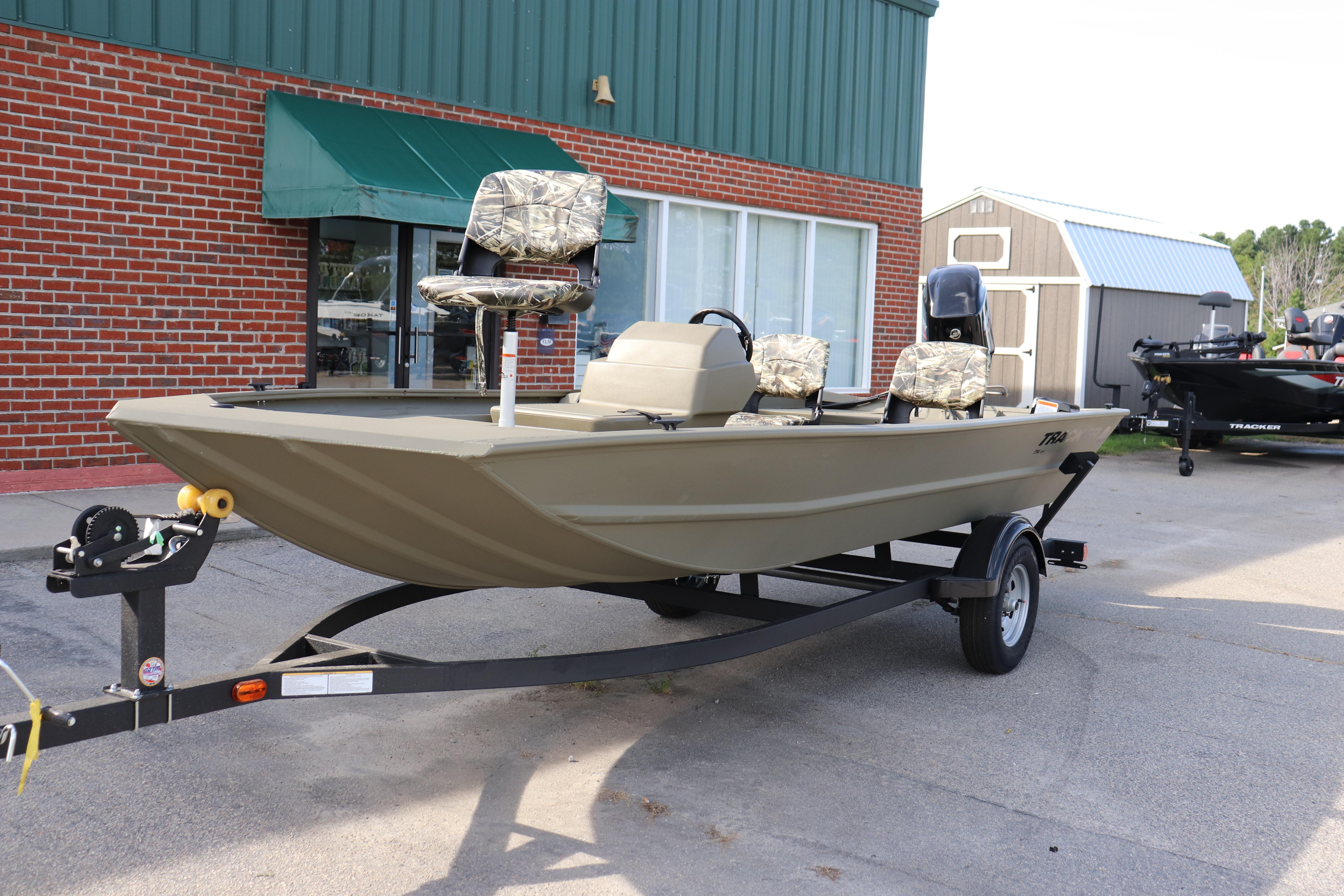 Tracker Grizzly 1754 SC 2026 Tracker Grizzly 1754 SC boat on trailer, parked outside a building.