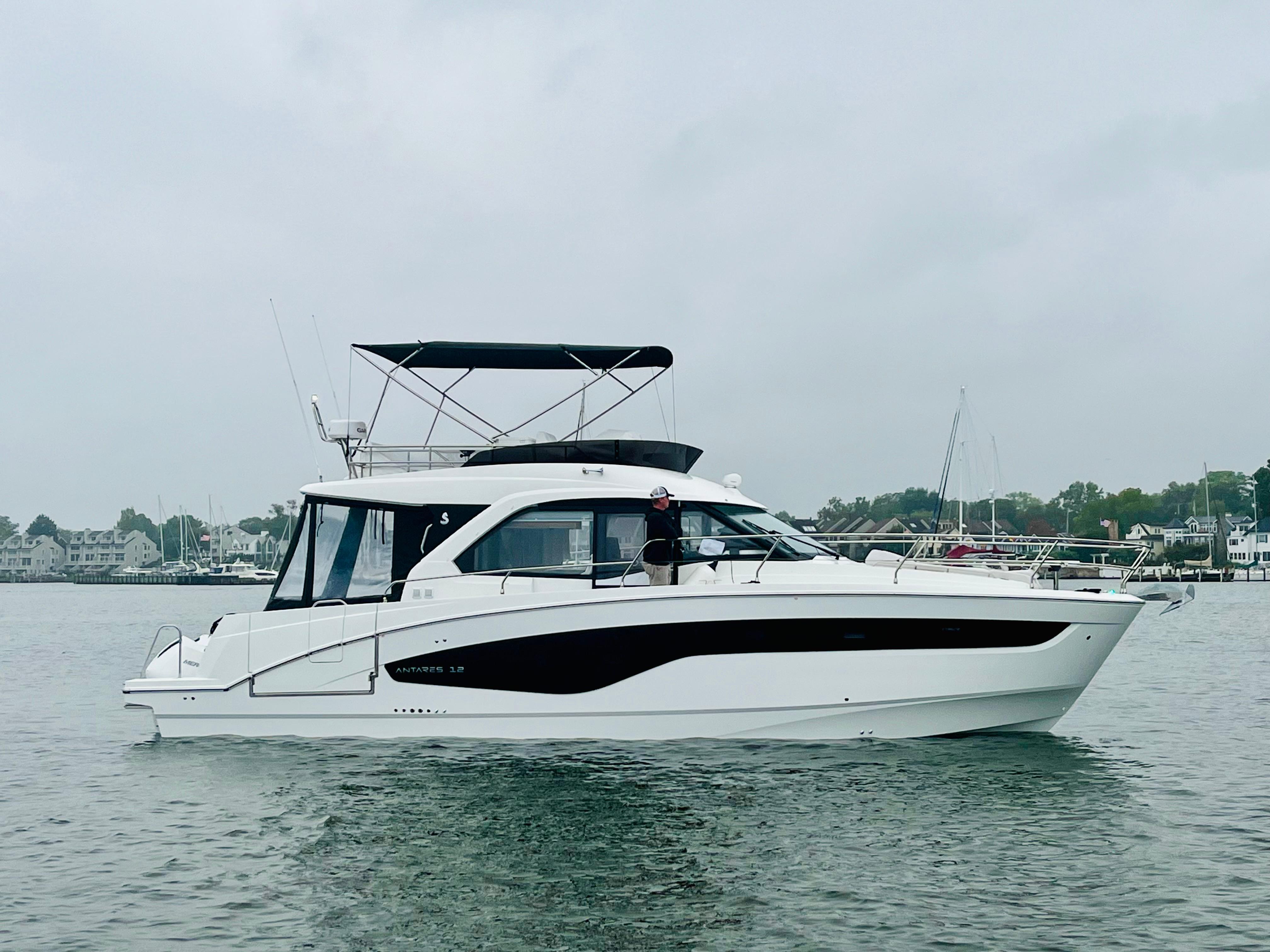 Beneteau Antares 12 2024 Beneteau Antares 12 yacht on calm water, overcast sky, coastal background.