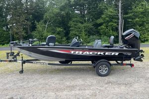 Tracker Pro Team 175 2026 Tracker Pro Team 175 boat on trailer, parked outdoors with forest background.