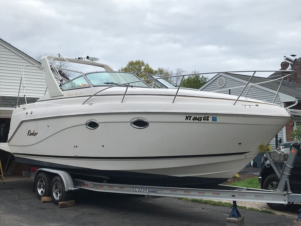 Rinker Fiesta Vee 270 2003 Rinker Fiesta Vee 270 boat on trailer, parked near a house.