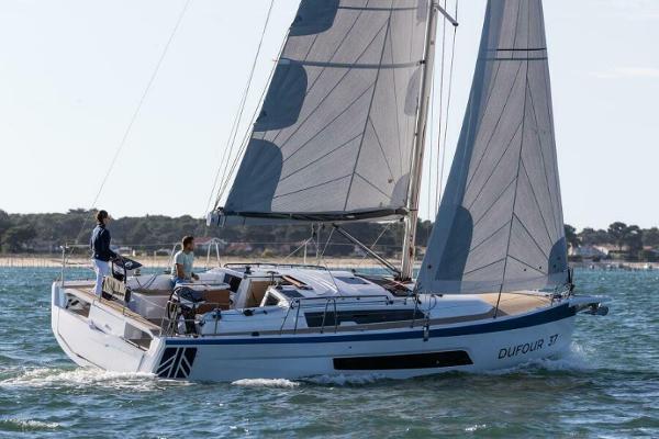 Dufour 37 2025 Dufour 37 sailboat navigating on open water with two people onboard.
