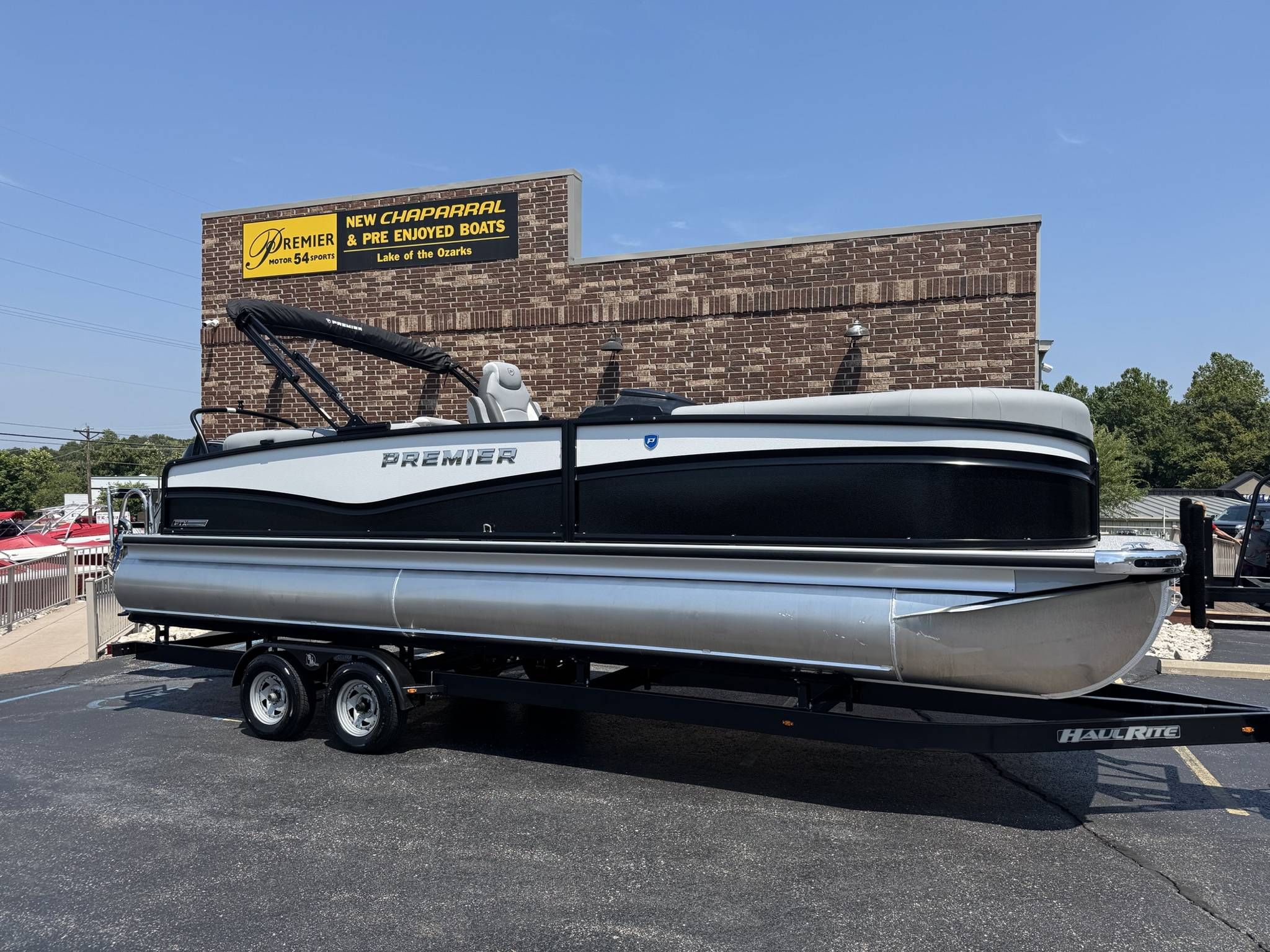 Premier 250 Solaris RF 2026 Premier 250 Solaris RF pontoon boat on trailer at dealership.