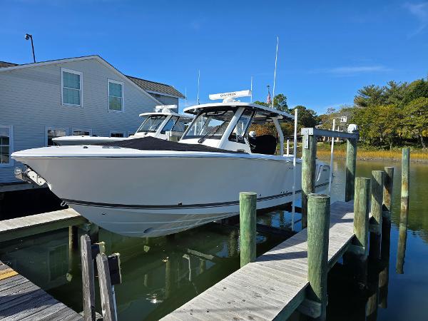 Pursuit S 328 2025 Pursuit S 328 boat docked at a marina under clear blue skies.