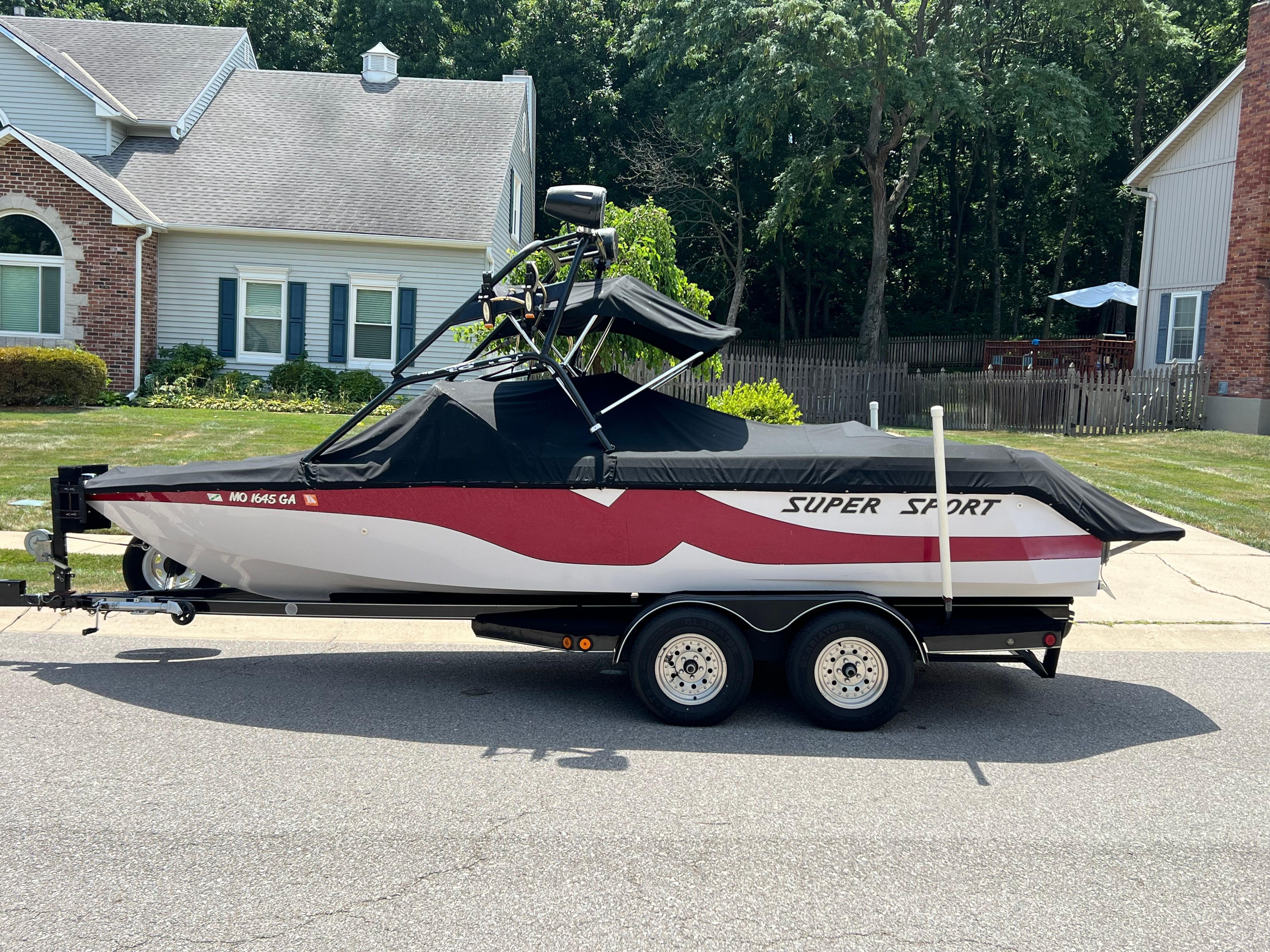 Nautique Super Sport 210 2001 Nautique Super Sport 210 boat on trailer, parked in residential area.
