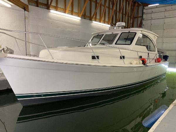 Mainship Pilot 2000 Mainship Pilot boat docked indoors, white hull with green stripe.