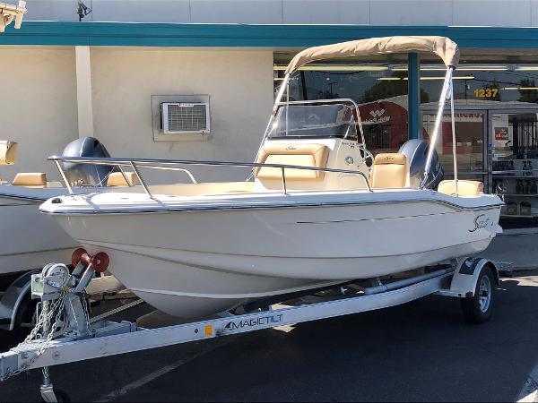 Scout 175 Sportfish 2024 Scout 175 Sportfish boat on a trailer outside a store.