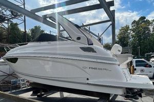 Regal 28 Express 2019 Regal 28 Express boat on a trailer in a marina setting under a blue sky.