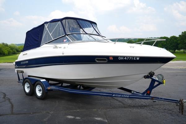 Four Winns 225 Sundowner 2002 Four Winns 225 Sundowner boat on trailer, parked outdoors.