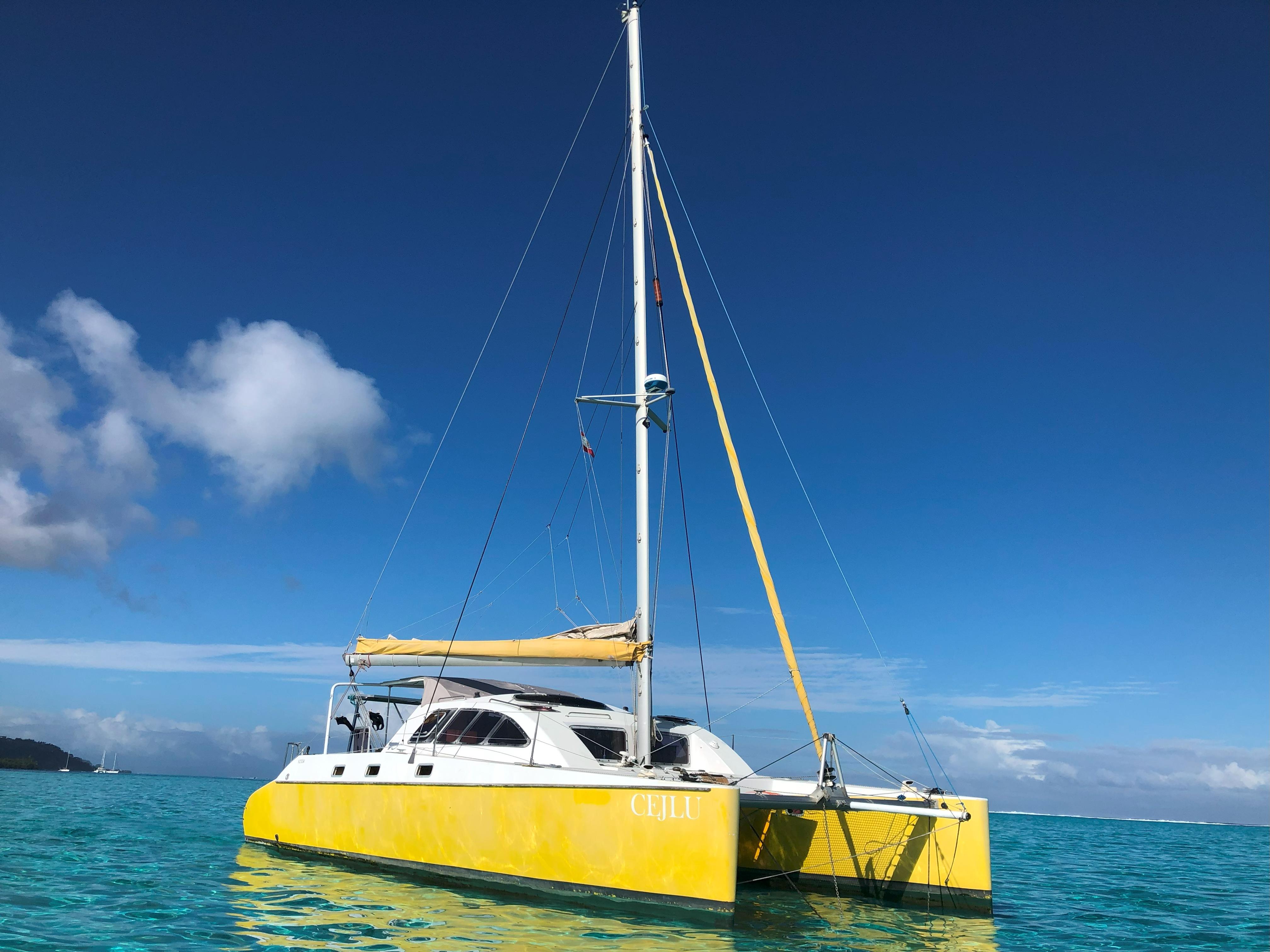 Custom Piana 40 Yellow Custom Piana 40 catamaran sailing on clear blue waters, 2006 model.