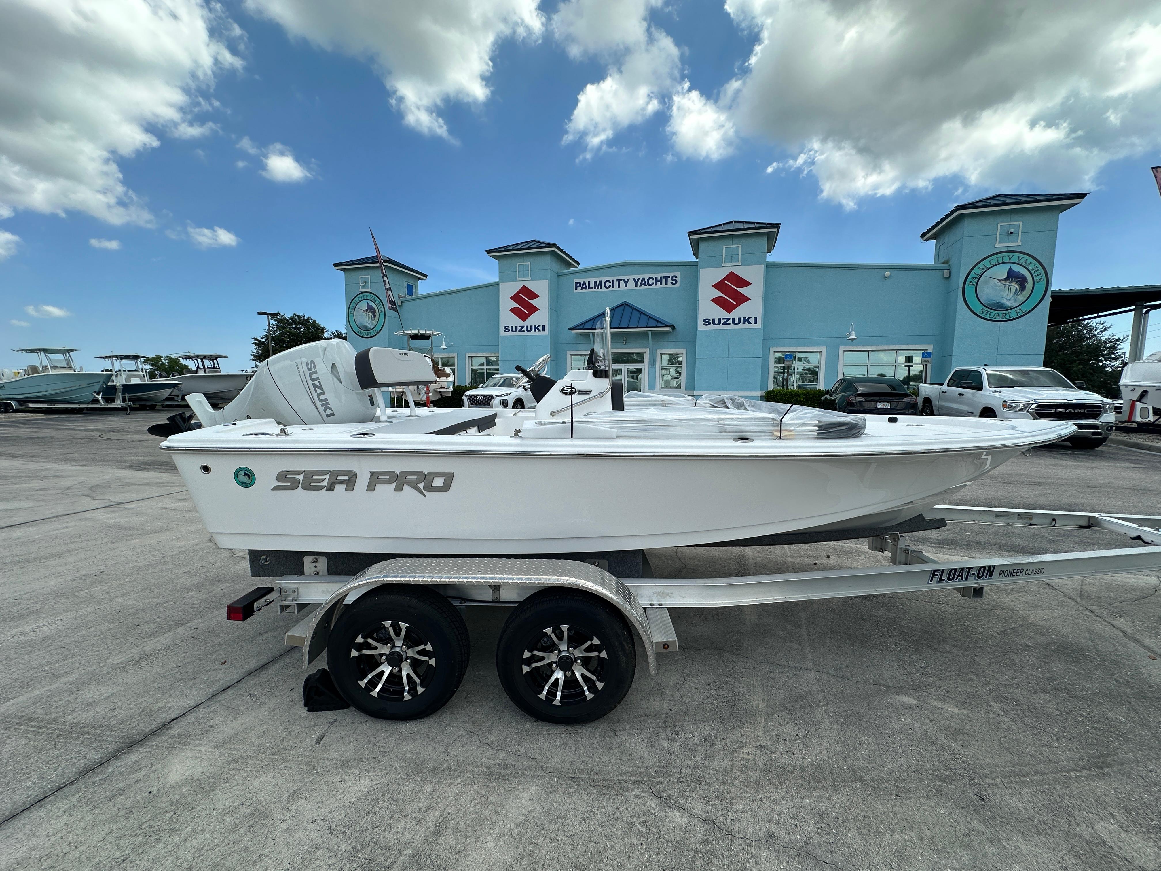 Sea Pro 172 Bay 2026 Sea Pro 172 Bay boat on trailer at dealership, under a partly cloudy sky.