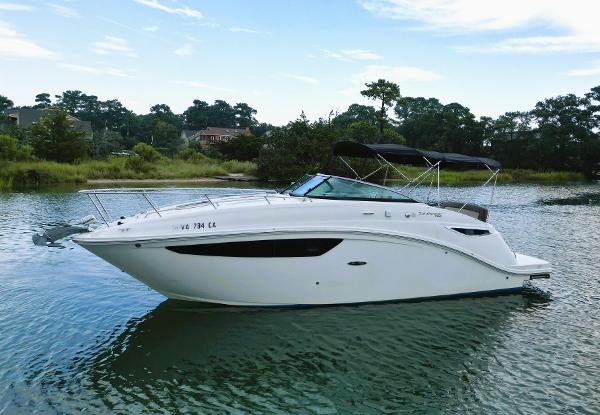 Sea Ray 260 Sundancer 2015 Sea Ray 260 Sundancer boat on calm water, surrounded by lush greenery.