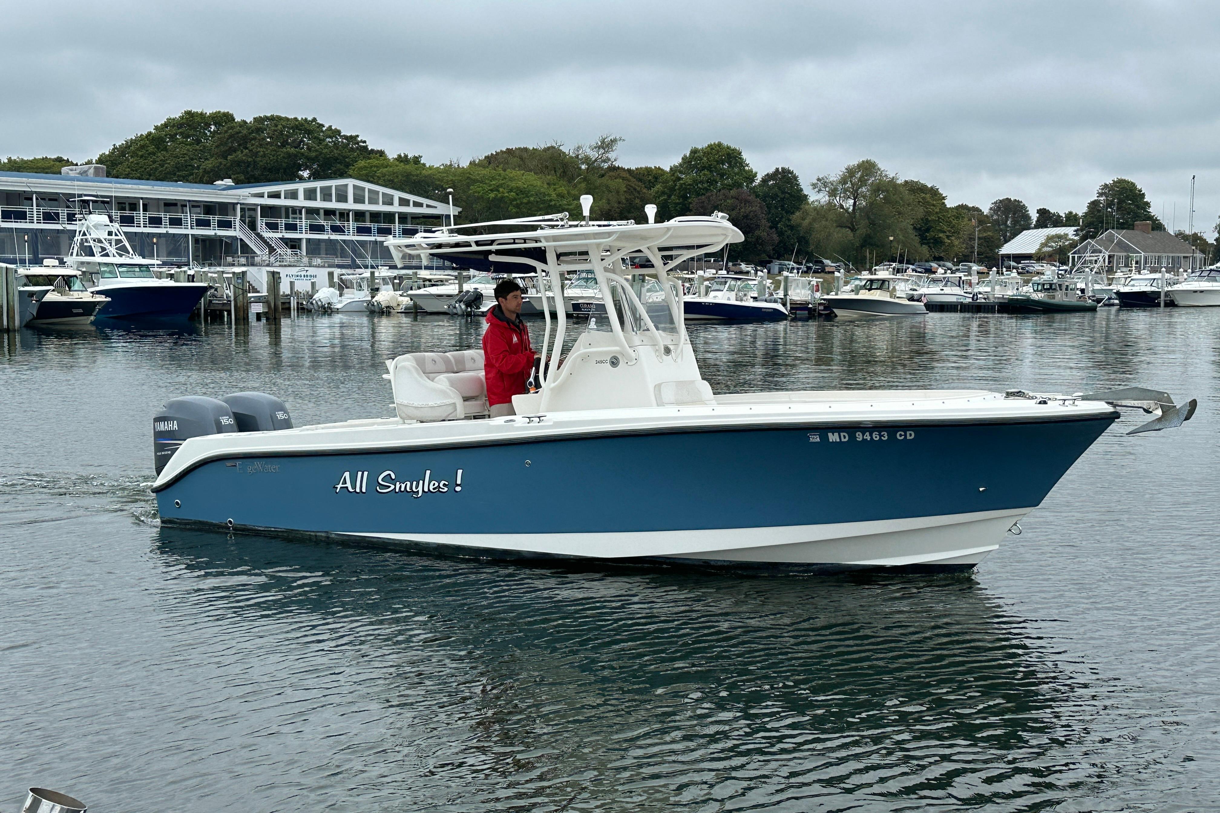 Edgewater 245CC 2012 Edgewater 245CC boat named "All Smyles" on calm marina waters.