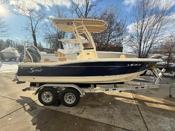 Scout 195 Sportfish 2024 Scout 195 Sportfish boat on trailer, parked outdoors in sunny weather.