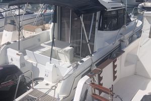 Jeanneau Merry Fisher 695 2019 Jeanneau Merry Fisher 695 boat docked with canopy and seating area.