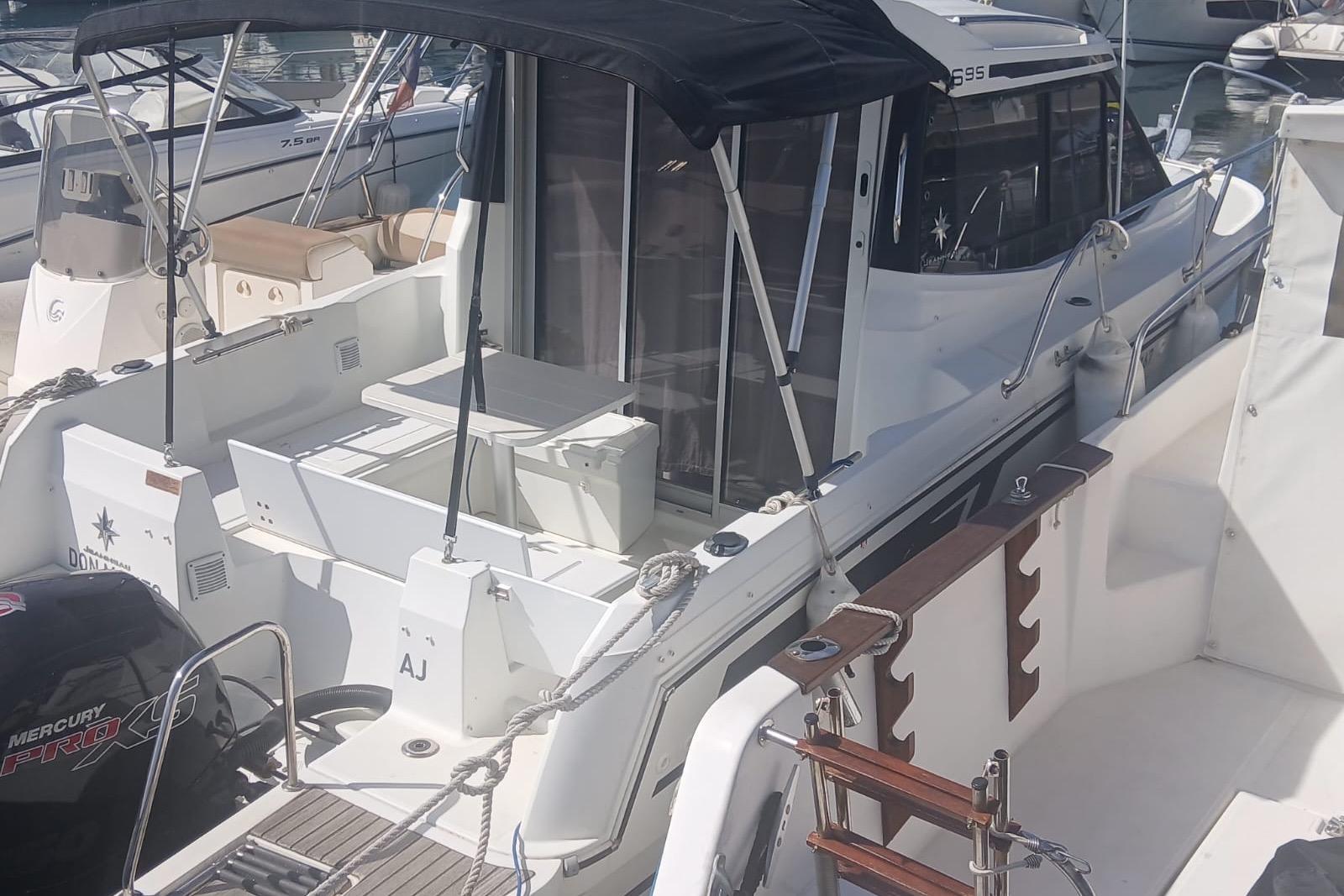 Jeanneau Merry Fisher 695 2019 Jeanneau Merry Fisher 695 boat docked with canopy and seating area.