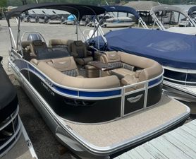 Bennington 23 LXSFB 2025 Bennington 23 LXSFB pontoon boat with luxurious seating and canopy, docked at marina.