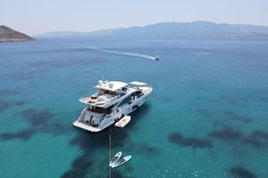 Azimut 80 Luxurious 2015 Azimut 80 yacht anchored in clear blue waters, with scenic mountain backdrop.