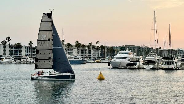 Beneteau First 27 Sailboat Beneteau First 27, 2022 model, cruising in a marina at sunset.
