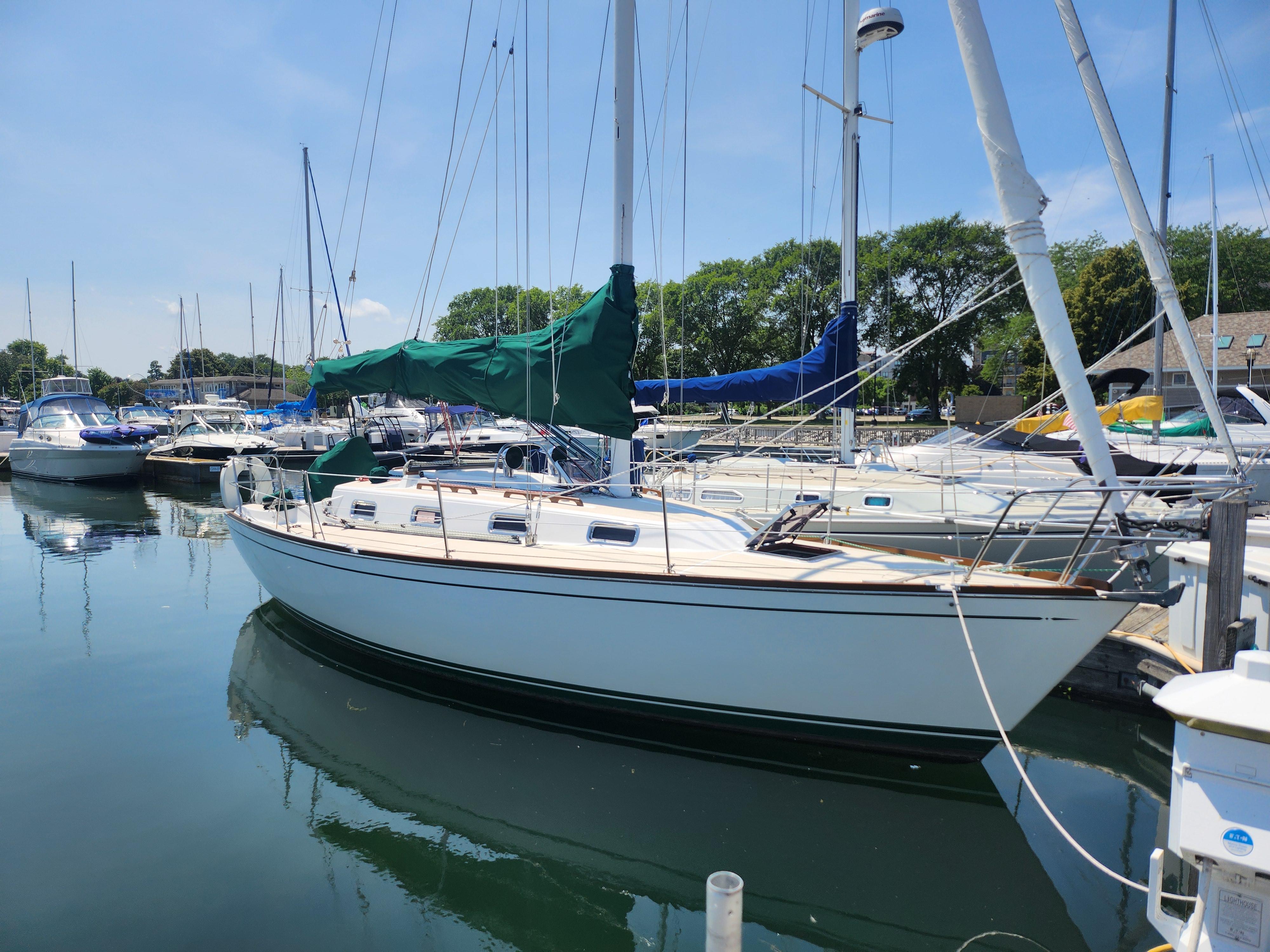 Tartan 31 Sailboat docked in marina, 1993 Tartan 31 model, clear sky, calm water.