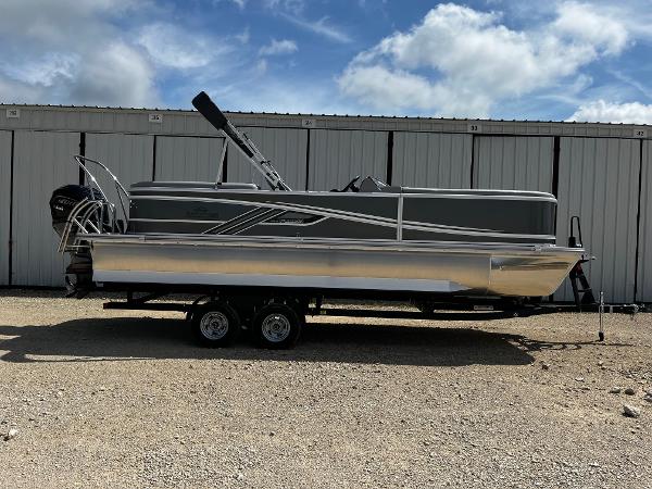 SunCatcher Fusion 324RC 2025 SunCatcher Fusion 324RC pontoon boat on trailer, parked outdoors under a cloudy sky.