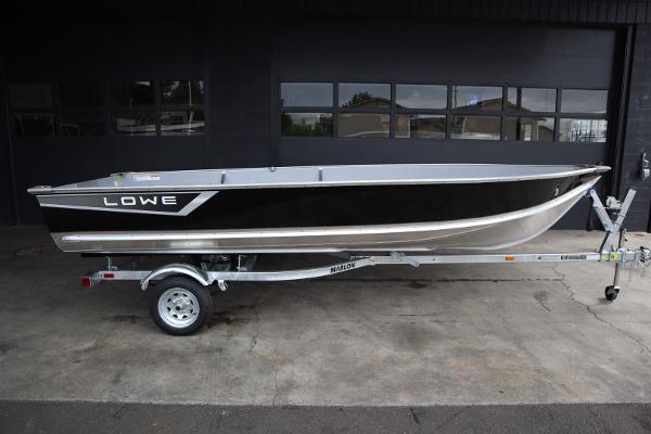 Lowe WV1670 2024 Lowe WV1670 boat on a trailer in front of a garage.