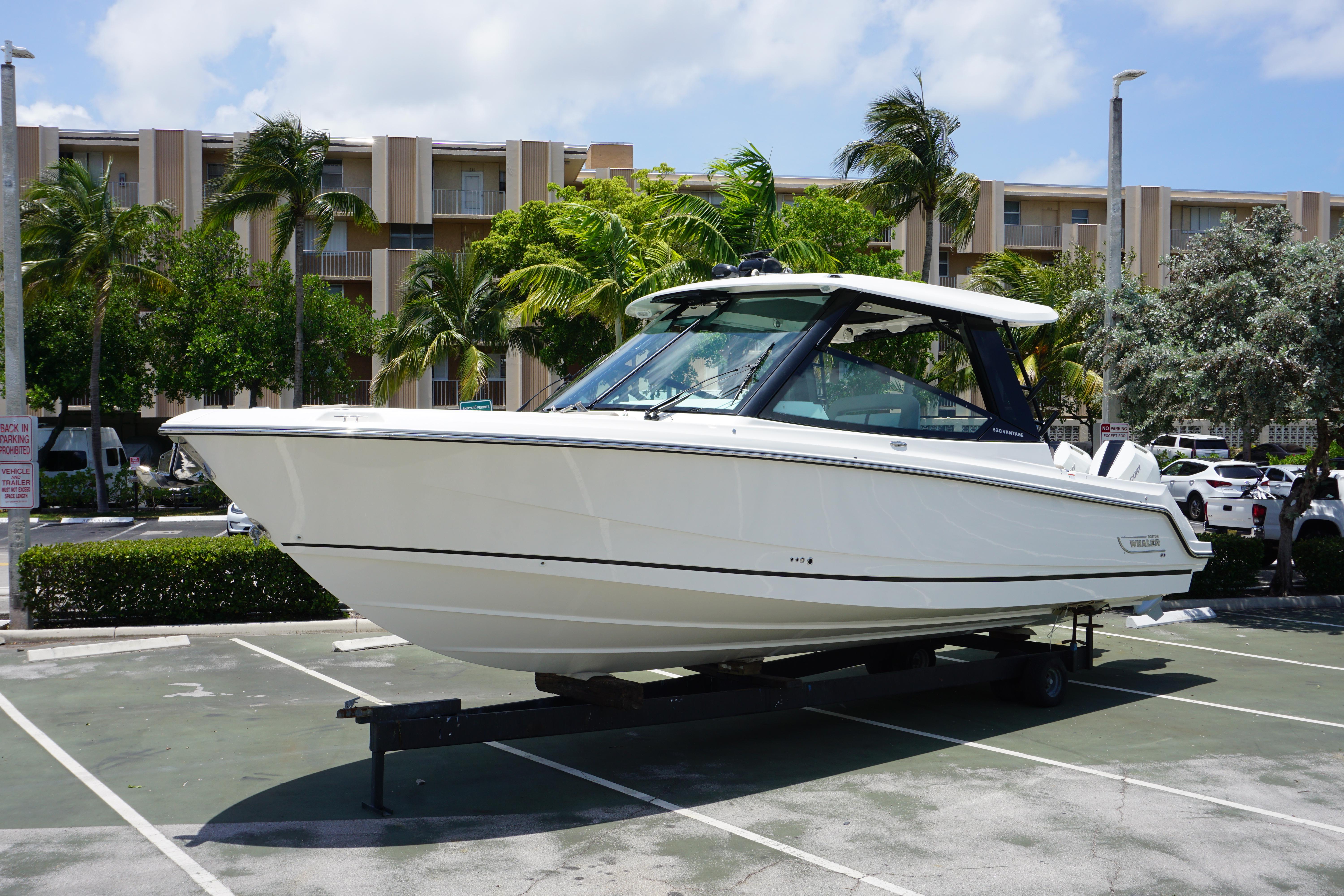 Boston Whaler 330 Vantage 2025 Boston Whaler 330 Vantage boat on trailer in sunny parking lot.