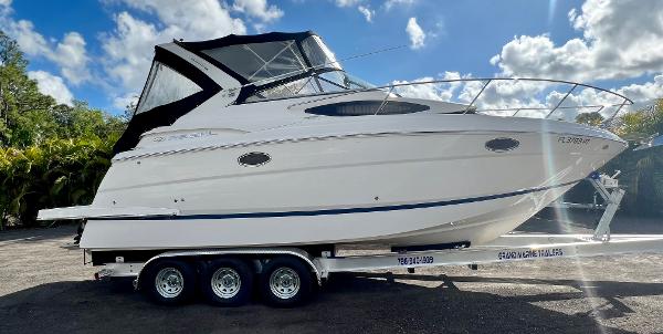 Regal 30 Express 2014 Regal 30 Express boat on a triple-axle trailer under a partly cloudy sky.