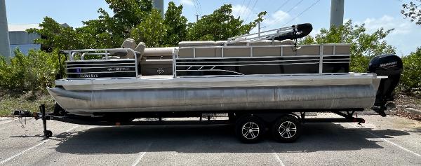 Sun Tracker SF24XP3 2023 Sun Tracker SF24XP3 pontoon boat on a trailer, parked outdoors.