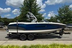 MasterCraft X24 2021 MasterCraft X24 boat on trailer, blue and white, parked outdoors.