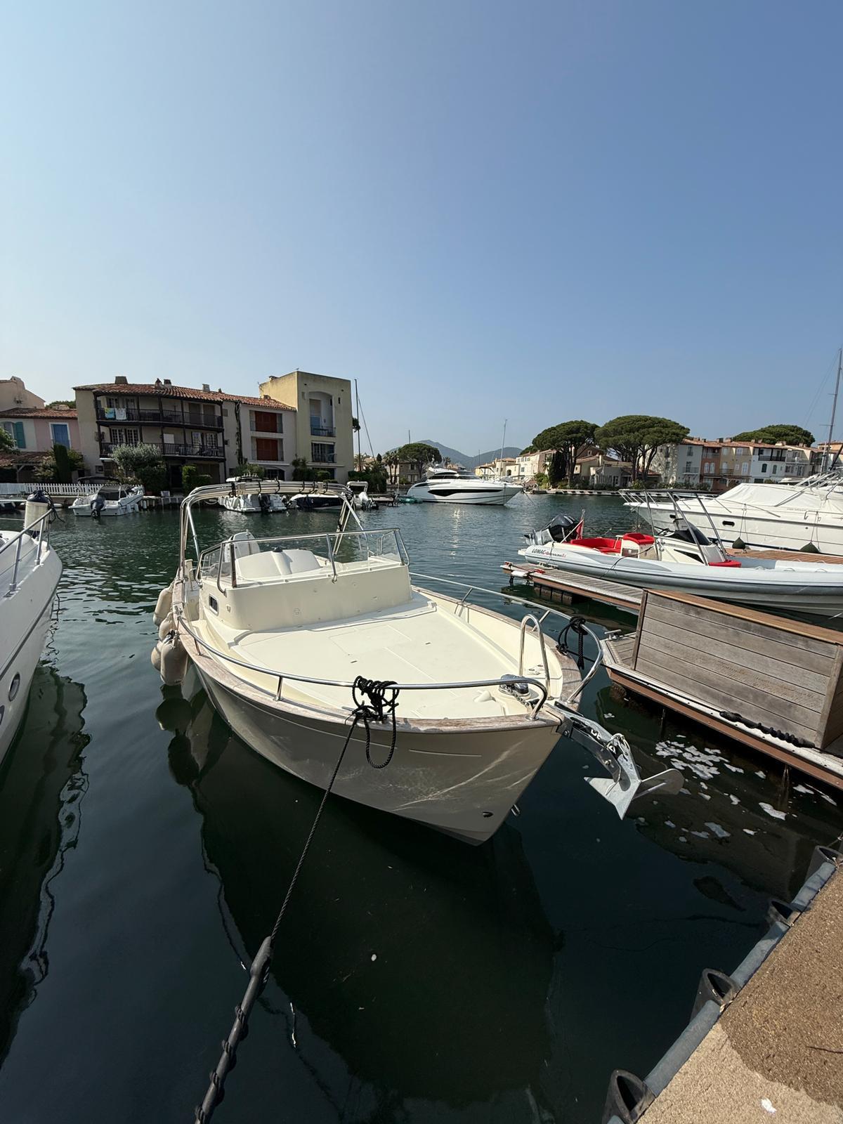 Rhea 27 Escapade 2022 Rhea 27 Escapade boat docked in a scenic marina.