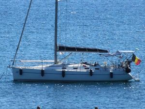 Harmony 38 Sailboat on blue water, Harmony 38 model, 2006, with flags and covered deck.