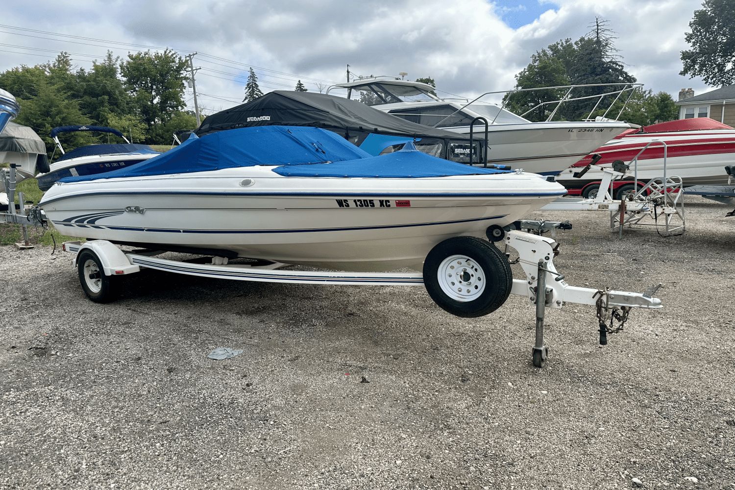 Sea Ray 175 Sport 1997 Sea Ray 175 Sport boat on trailer with blue cover, parked outdoors.