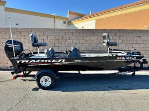 Tracker Pro 170 2024 Tracker Pro 170 boat with Mercury engine, parked on a trailer, against a brick wall.