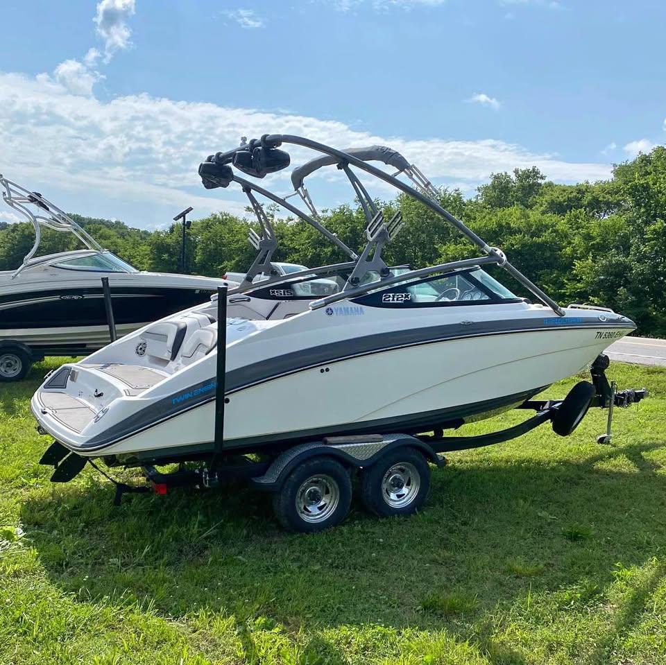Yamaha Boats 212X 2015 Yamaha Boats 212X on trailer, parked on grass under a clear sky.