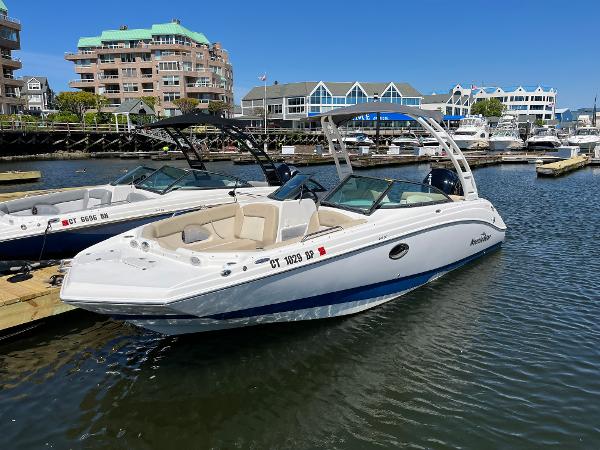 NauticStar 243 DC 2022 NauticStar 243 DC boat docked in a marina with waterfront buildings.