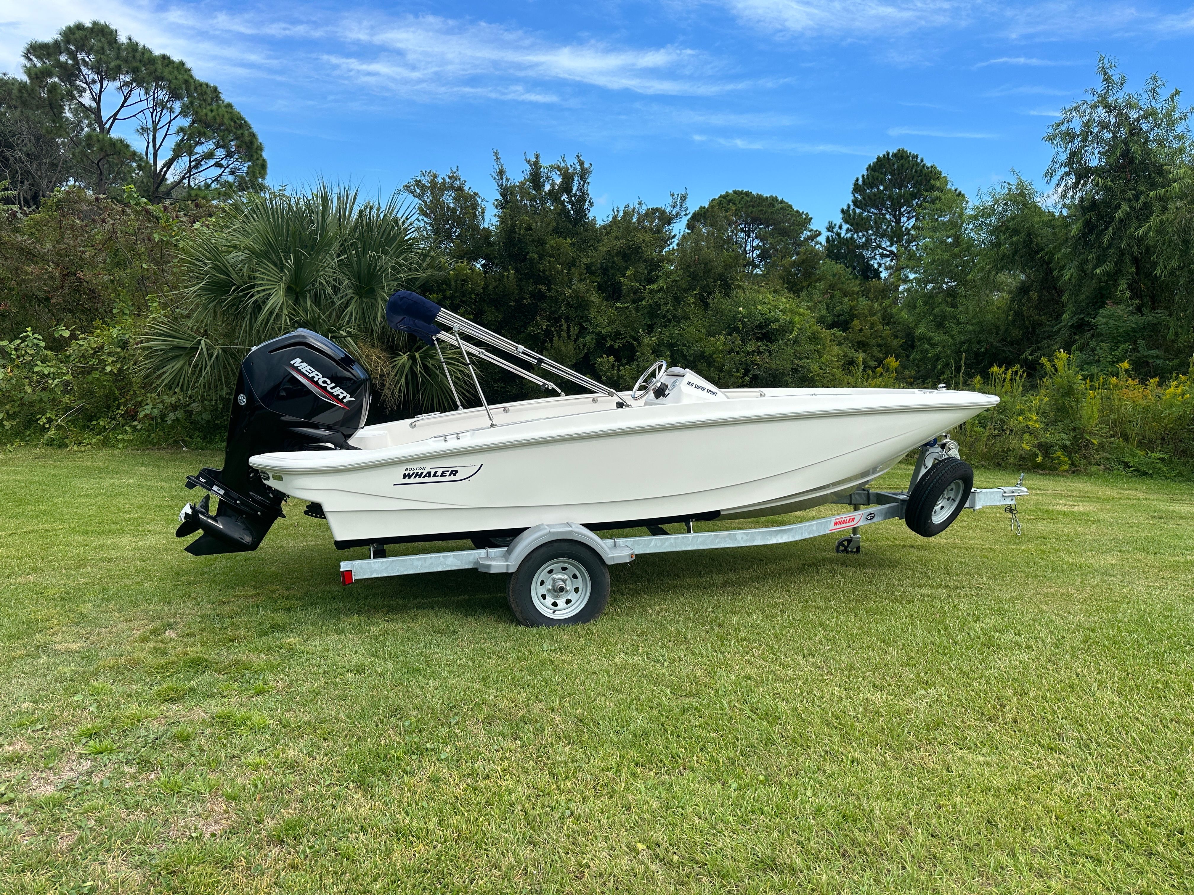 Boston Whaler 160 Super Sport 2025 Boston Whaler 160 Super Sport boat on trailer, parked on grassy field.