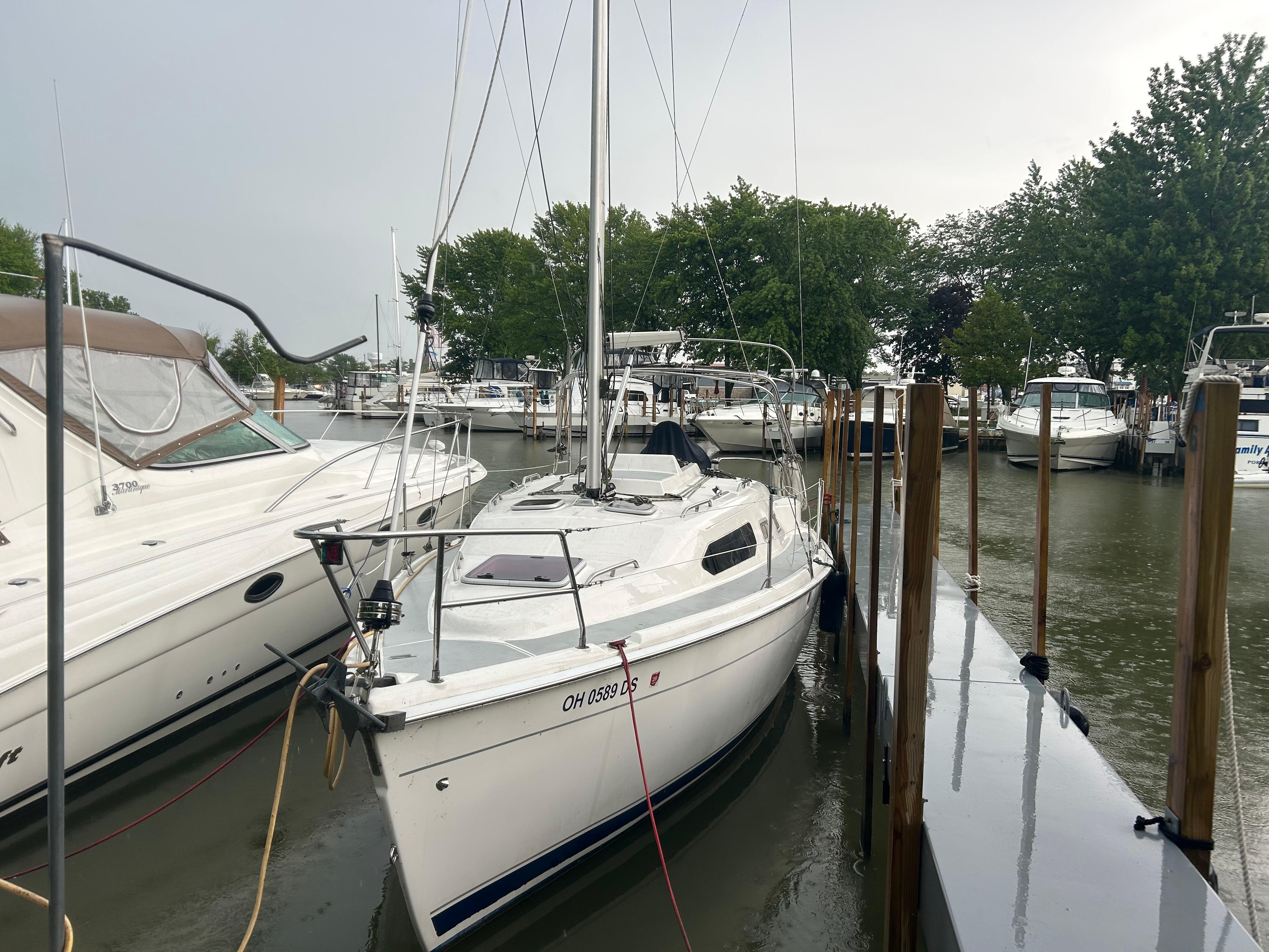 Hunter 306 2004 Hunter 306 sailboat docked at marina, surrounded by other boats and trees.