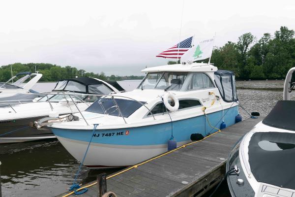 Bayliner Discovery 246 2007 Bayliner Discovery 246 docked, featuring American flag and lush green backdrop.