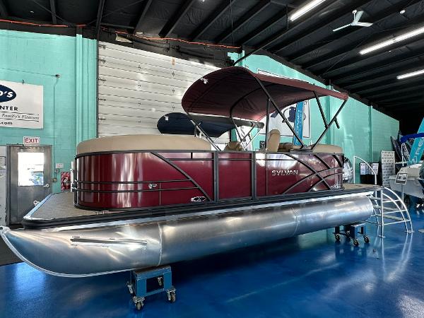 Sylvan Mirage X1 2025 Sylvan Mirage X1 pontoon boat displayed indoors on a blue floor.