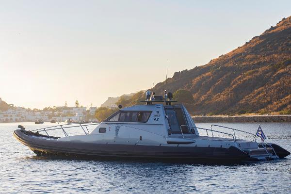 FB Design 42 SF FB Design 42 SF boat from 2010 on calm water near a mountainous coastline.