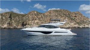 Princess S66 2022 Princess S66 yacht cruising near rocky coastline under blue sky.