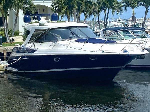 Regal 46 Sport Coupe 2011 Regal 46 Sport Coupe yacht docked in marina, surrounded by palm trees.