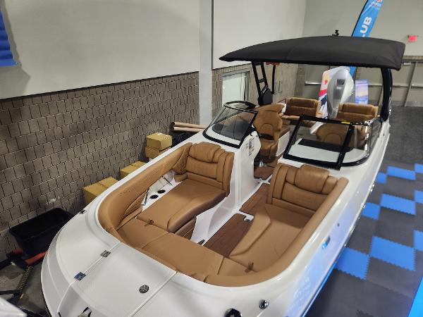 Hurricane SunDeck 2600 OB 2025 Hurricane SunDeck 2600 OB boat with tan seating and black canopy in showroom.