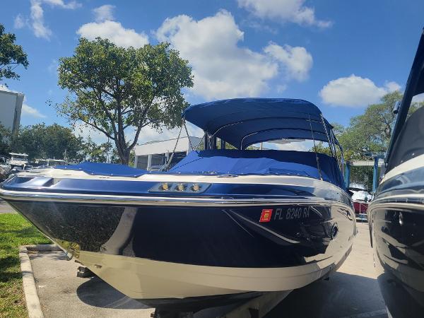 Chaparral 250 Suncoast 2015 Chaparral 250 Suncoast boat with blue canopy, parked outdoors under a sunny sky.
