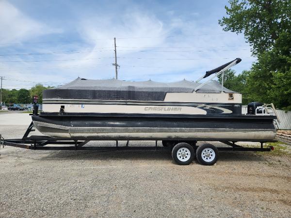 Crestliner LSI 248 S 2000 Crestliner LSI 248 S pontoon boat on trailer, parked outdoors.