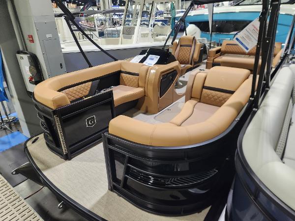 Godfrey AquaPatio 255 SFL 2025 Godfrey AquaPatio 255 SFL luxury pontoon boat with tan seating at a boat show.