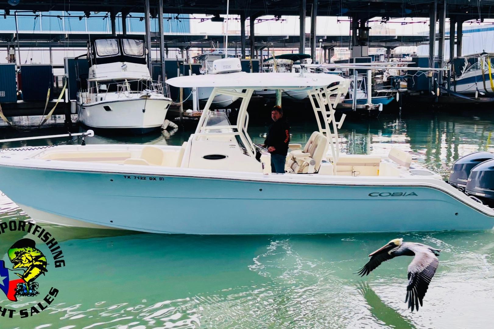 Cobia 296 Center Console 2017 Cobia 296 Center Console boat docked, with a pelican flying nearby.