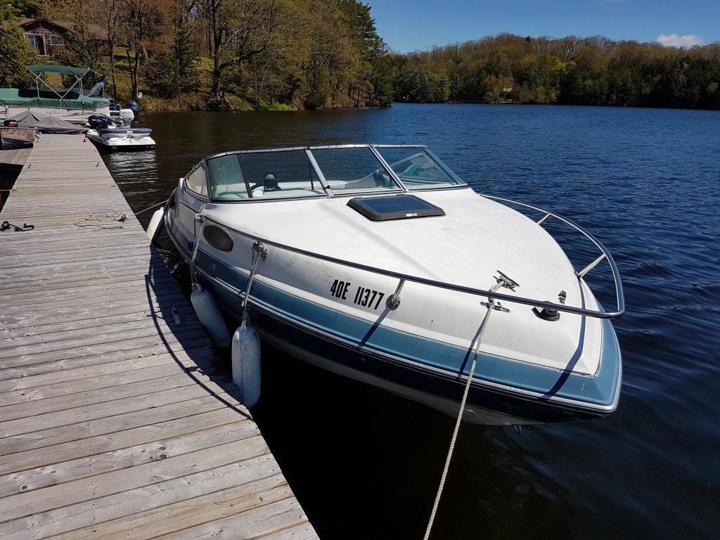 Chaparral 2050 SL Sport 1990 Chaparral 2050 SL Sport boat docked on a serene lake.