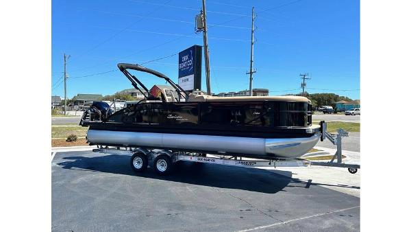 Barletta Cabrio 2024 Barletta Cabrio pontoon boat on a trailer in a parking lot.